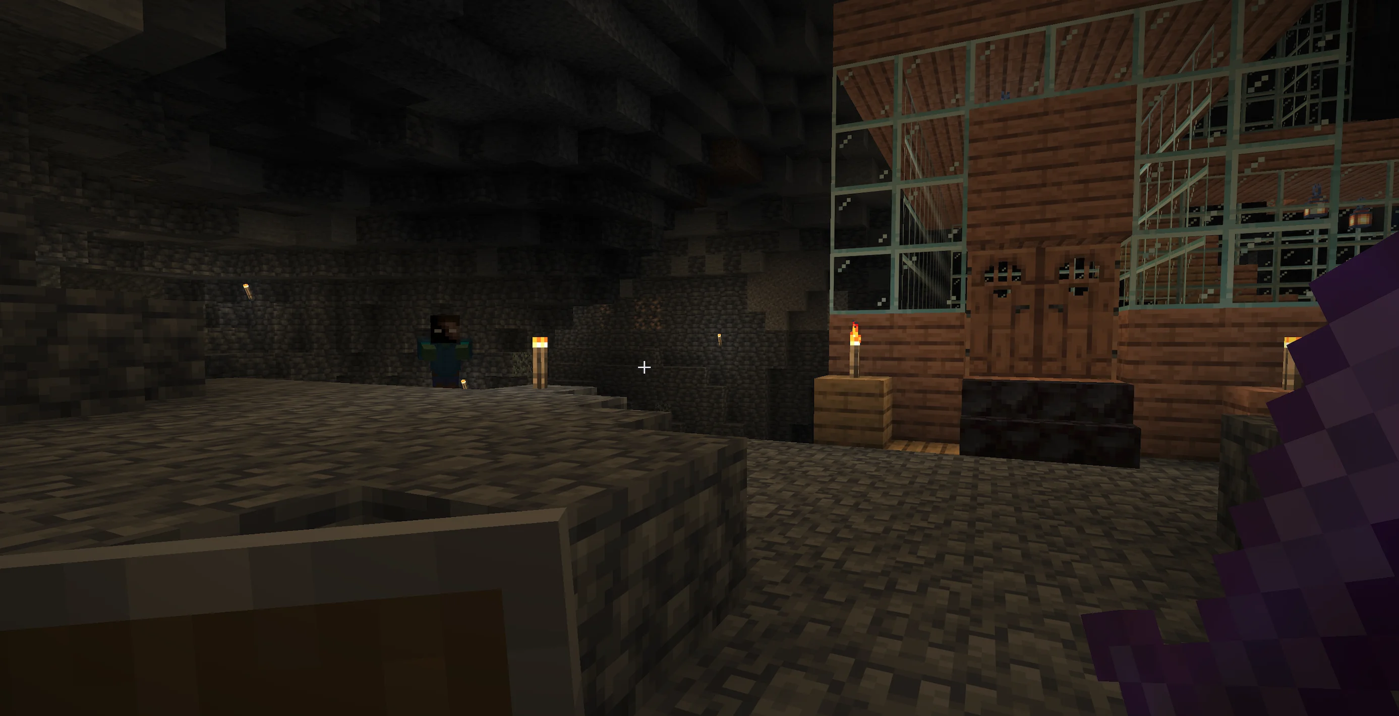 a screenshot from Minecraft of the player down in a large stone cave with scaffolding and corridors built from wood to the right, and to the left is a torch and the herobrine entity with glowing white eyes
