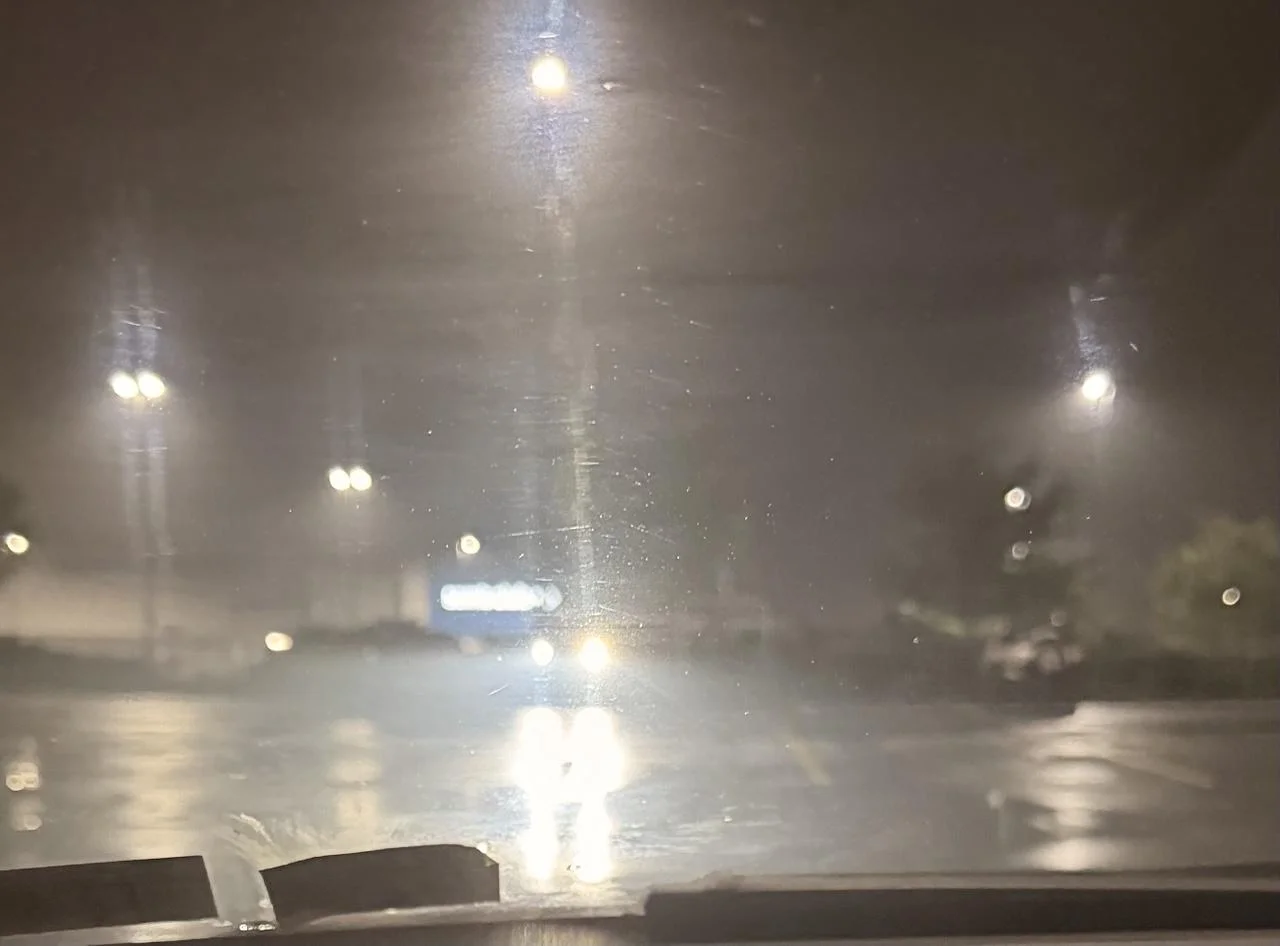 A photo through my windshield in a parking lot of LED headlights pointed right at me 