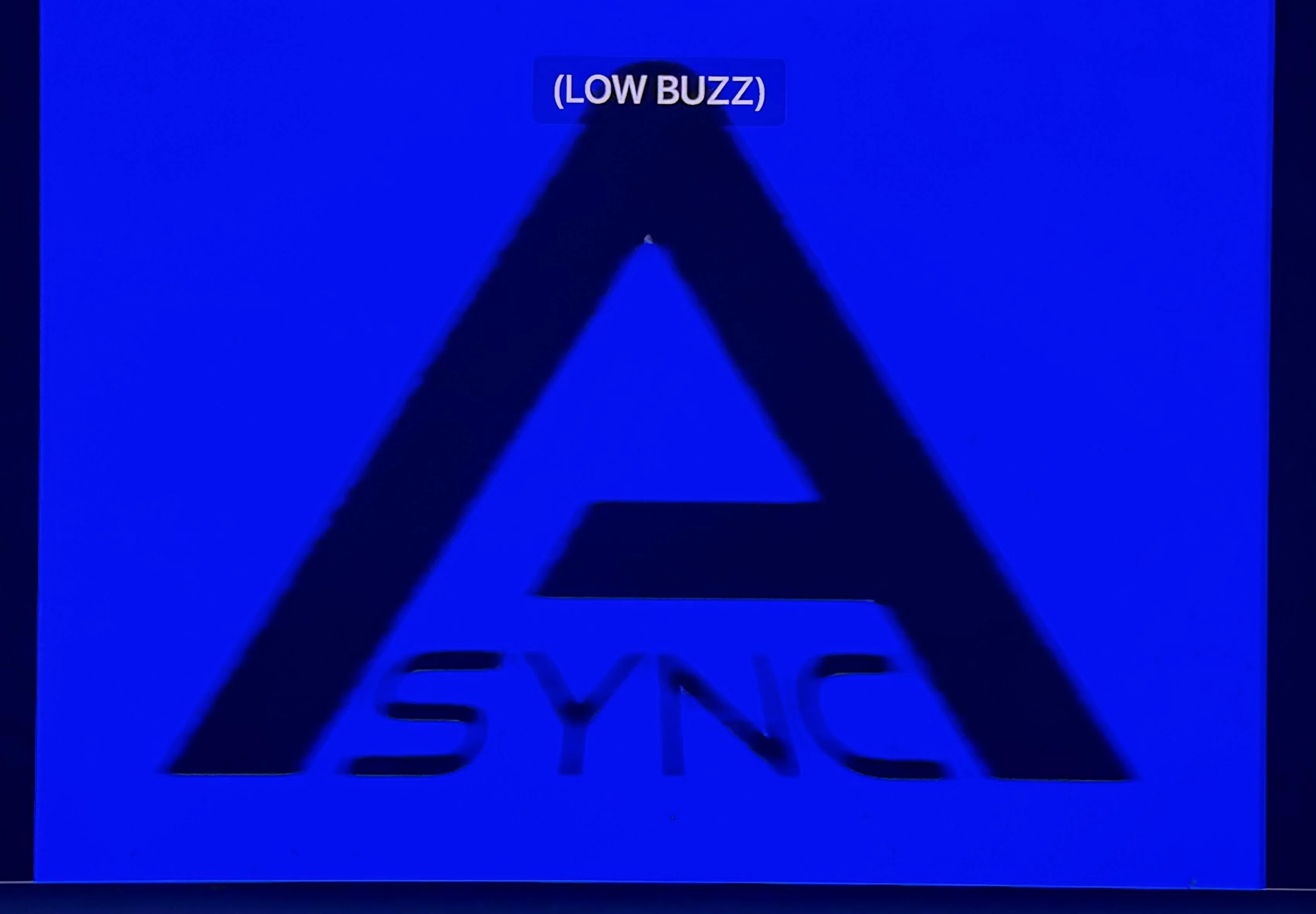 a photo of the opening scene of the movie Backrooms, a bright blue background with a large black letter A and in black lettering within the "A" is "SYNC", spelling ASYNC